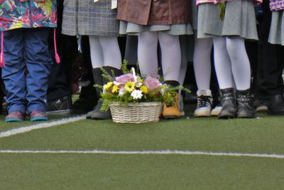 Low section of people by plants in basket