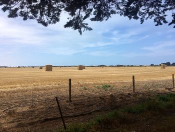 Hay bales on field against sky