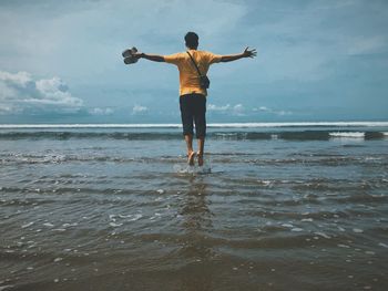 Full length rear view of man standing on beach