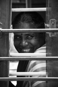 Smiling woman looking through window of bus