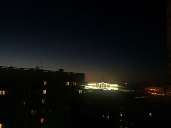 Illuminated buildings against sky at night