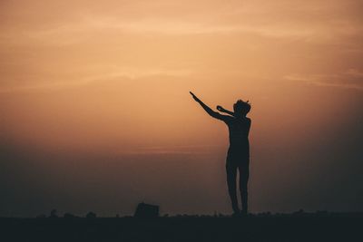 Silhouette man jumping against sky during sunset