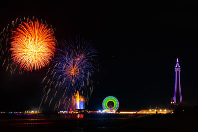 Low angle view of firework display at night