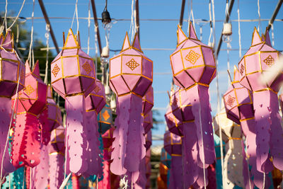 Close-up of multi colored umbrellas hanging against sky