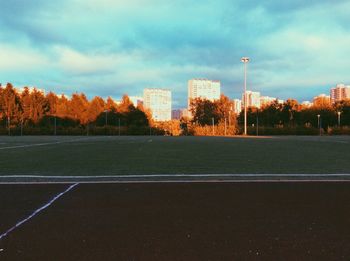 Empty road amidst buildings against sky