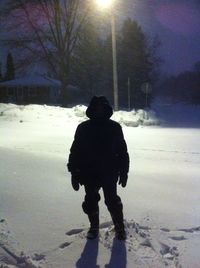 Silhouette man standing on snow covered landscape