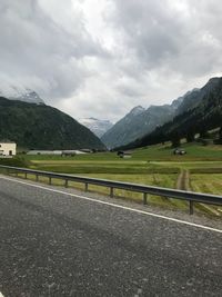 Road leading towards mountains against sky