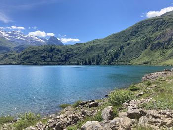 Scenic view of lake by mountains against sky