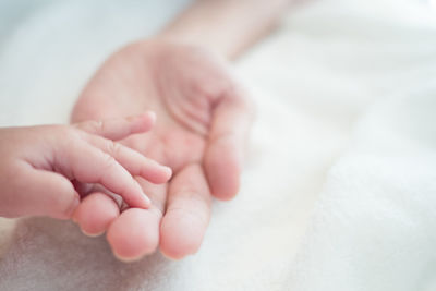 Close-up of baby hand on bed