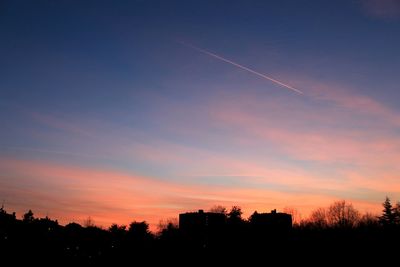 Silhouette trees against sky at sunset