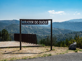 Information sign on landscape against sky