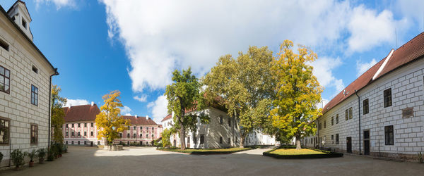 Panoramic view of buildings and trees against sky