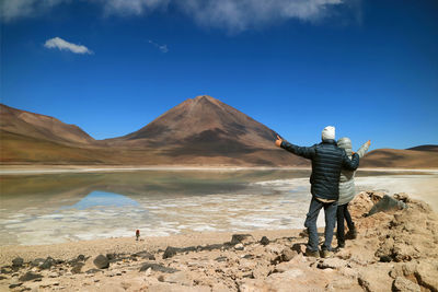 Rear view of couple standing against mountain