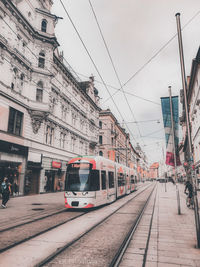 Railroad tracks amidst buildings in city against sky