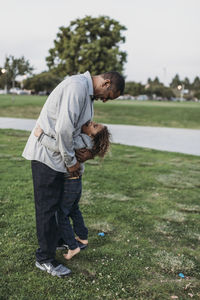 Happy father and son embracing outside at park at dusk