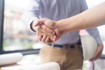 Cropped image of man shaking hand with colleague in office