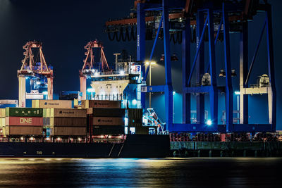 Illuminated harbor against sky at night