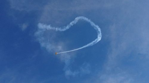 Low angle view of vapor trail against blue sky