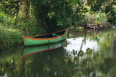 Boat moored on lake by trees