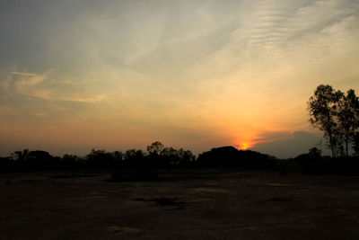 Scenic view of silhouette field against sky during sunset