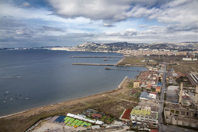 High angle view of city by sea against sky