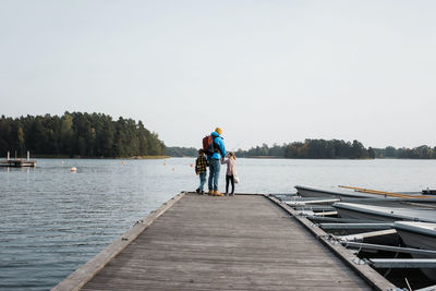 Father and his children happily fishing on the end of a pier together