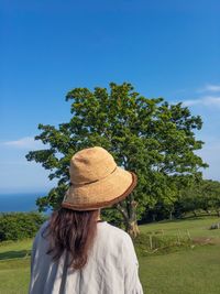 Rear view of woman on field against sky