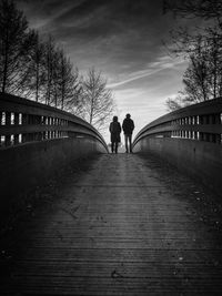 Rear view of people walking on footpath