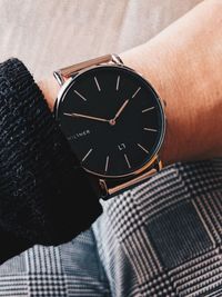 High angle view of human hand on clock