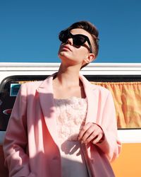 Young woman in sunglasses against sky