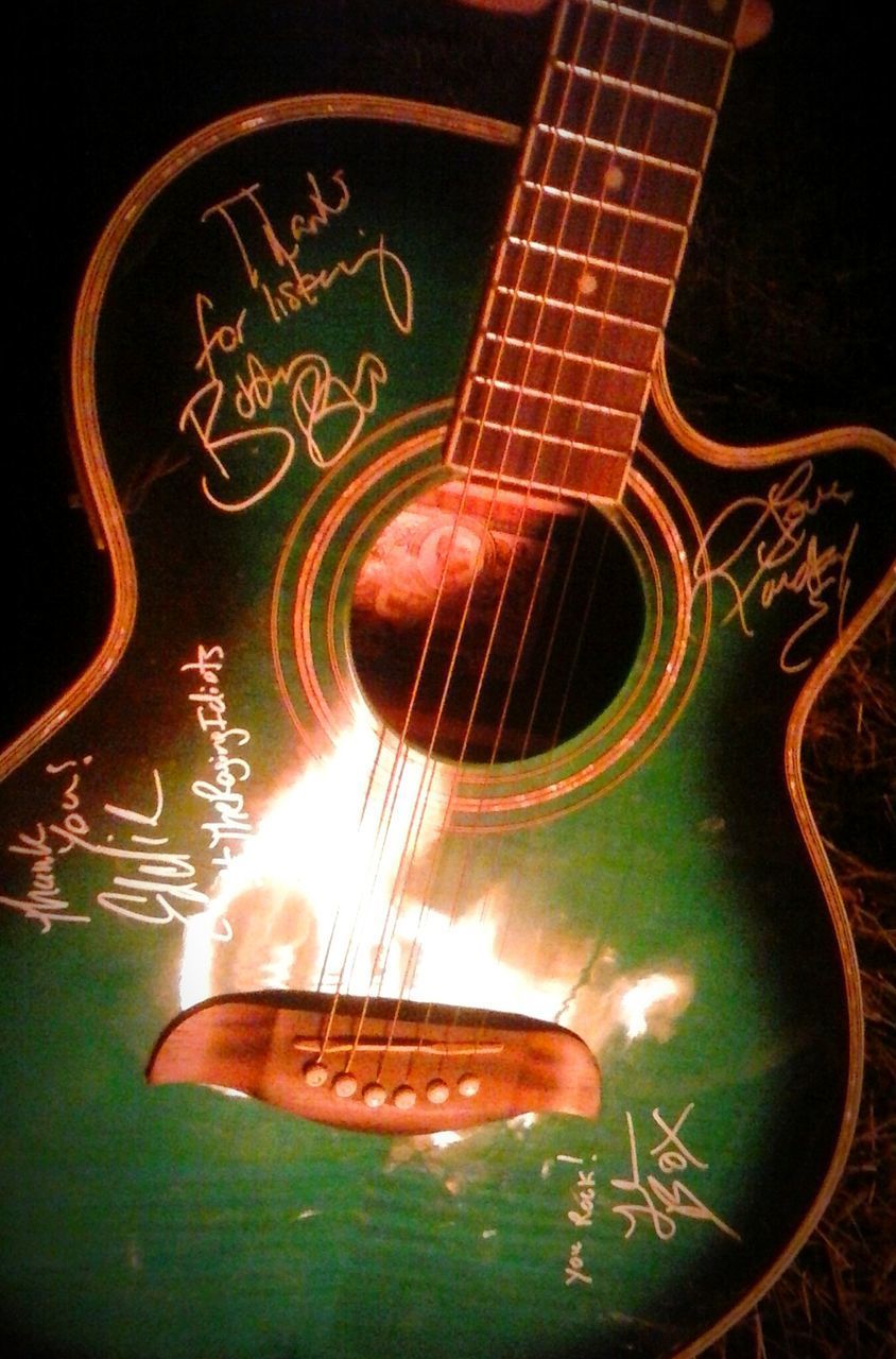 CLOSE-UP OF GUITAR IN ILLUMINATED ELECTRIC ROOM