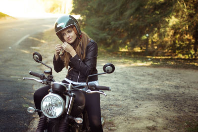 Young woman on motorcycle on road