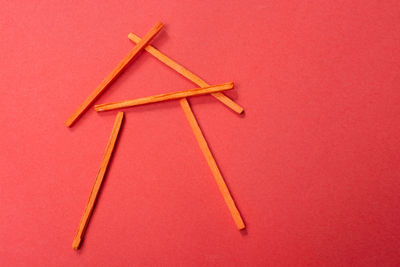 High angle view of colored pencils on table against red background