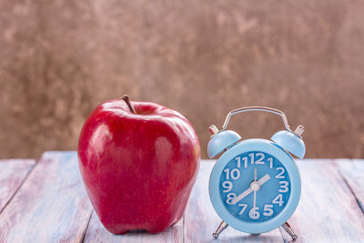 Close-up of clock on table against wall