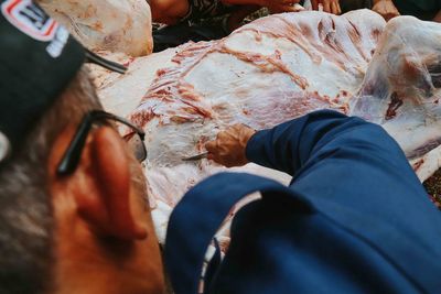 High angle view of butcher cutting meat