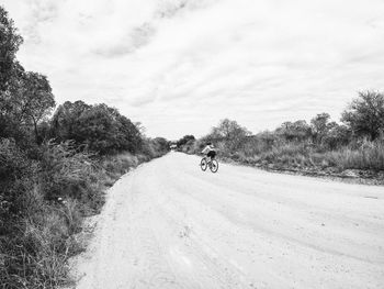 View of man riding motorcycle on road