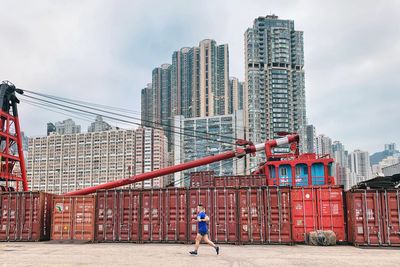 Man and buildings in city against sky