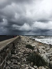 Scenic view of beach against storm clouds