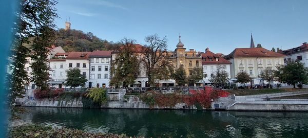 Buildings by lake against sky