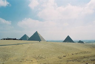 Scenic view of desert against cloudy sky