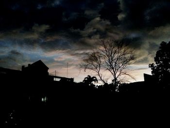 Silhouette of buildings against cloudy sky