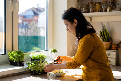 Side view of young woman at home