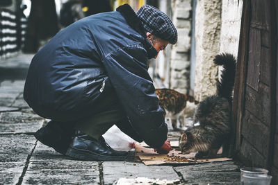 Side view of man with cat on street