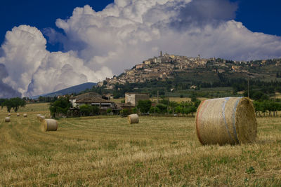 Hay bales on field against sky