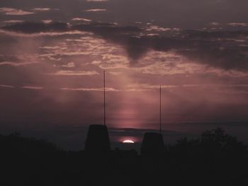 Silhouette of trees against cloudy sky