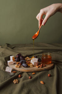 Midsection of person pouring bread on table