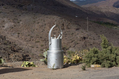 Metal structure on field against mountain