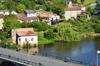 High angle view of houses by river amidst buildings