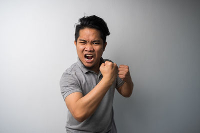 Portrait of man standing against white background