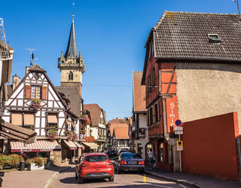 Cars on street amidst buildings against clear sky